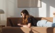 a person lying on a couch with a laptop